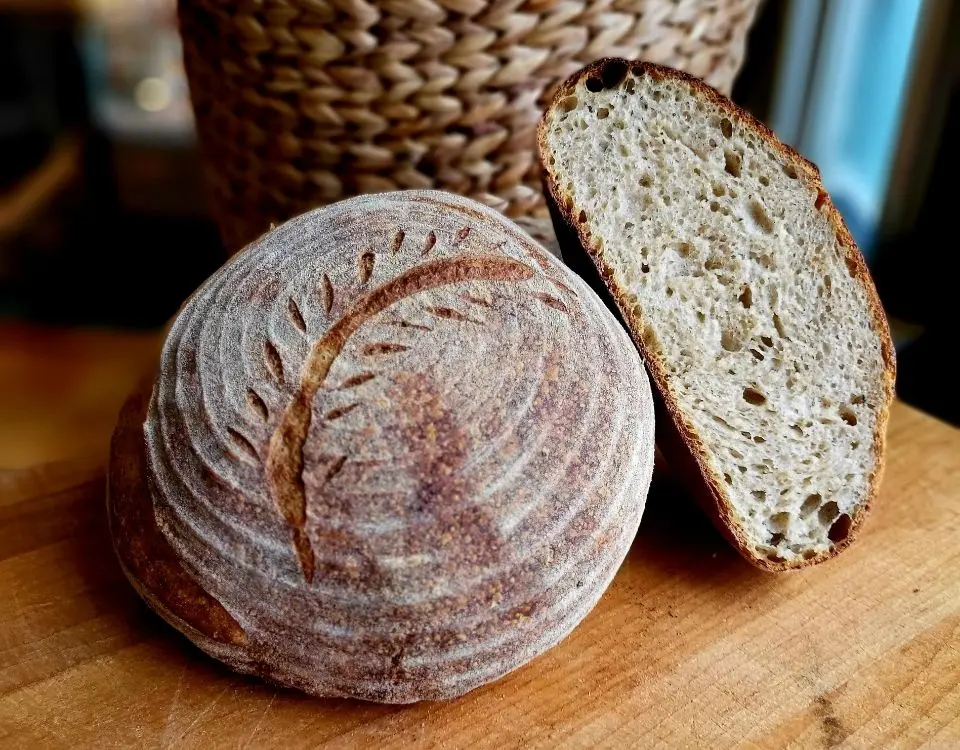 A loaf of sourdough bread sitting on a cutting board.